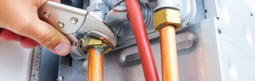 Plumber repairing a gas boiler of a heating home system